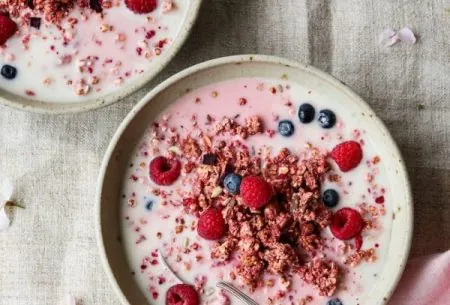 Two bowls of museli with fresh blueberries and raspberries