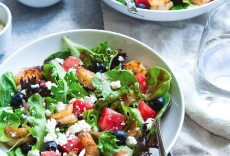 A leafy green salad with prawns, blueberries, feta and watermelon