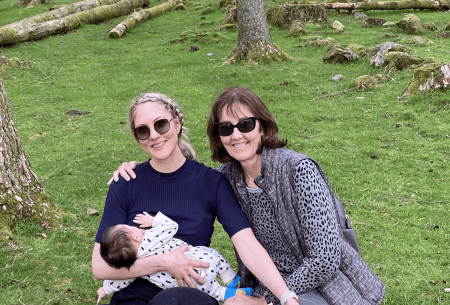 Dr Megan Rossi sitting outside on the grass with mother and new born child