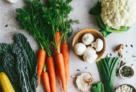 A variety of fresh and colourful vegetables spread out across a benchtop