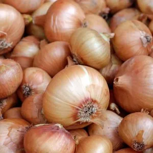 A photo of a pile of brown onions