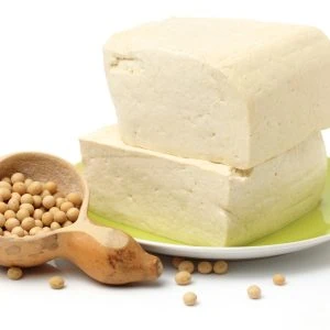 A photo of silken tofu on a plate with chickpeas next to it