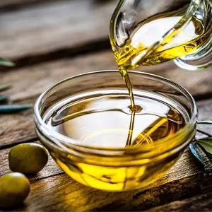 A photo of olive oil being poured into a small glass bowl