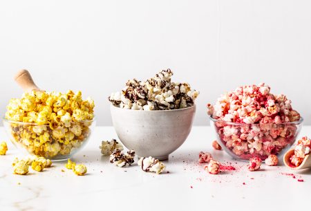 Three bowls of popcorn with the three different toppings on each