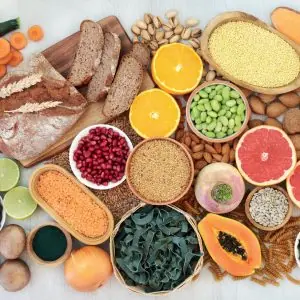 A photo of foods high in fibre set across a table, it includes papaya, grapefruit, bread