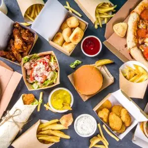 A photo of fast food spread out across the table. It includes burgers, fries and chicken nuggests.