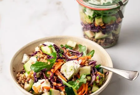 A bowl of the zingy salad with a jar in the background