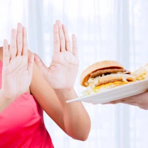 A photo of a woman refusing a beef burger