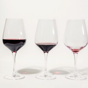A photo of three glasses of wine with different amounts in them