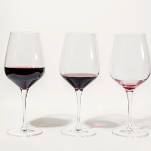 A photo of several glasses of wine with different amounts in them