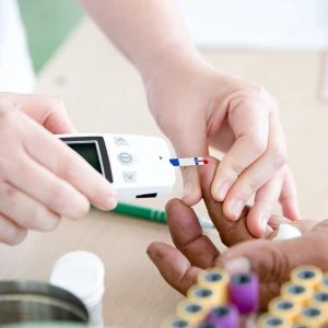 A photo of someone measuring another persons blood sugar levels