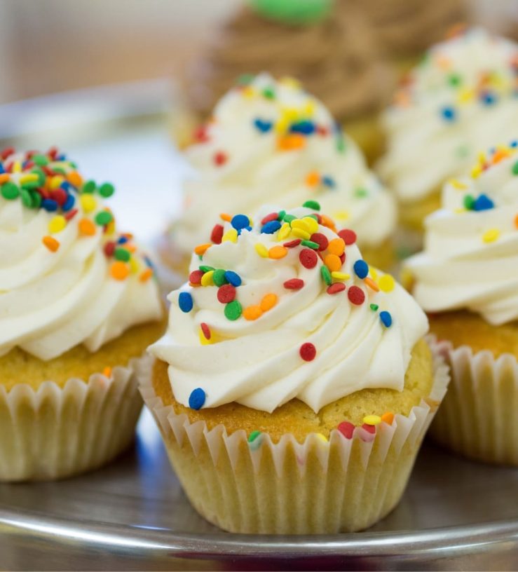 A photo of cupcake with icing and sprinkles