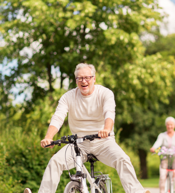 Photo of a middle aged man cycling joyfully to showing positive mental health via workplace wellbeing