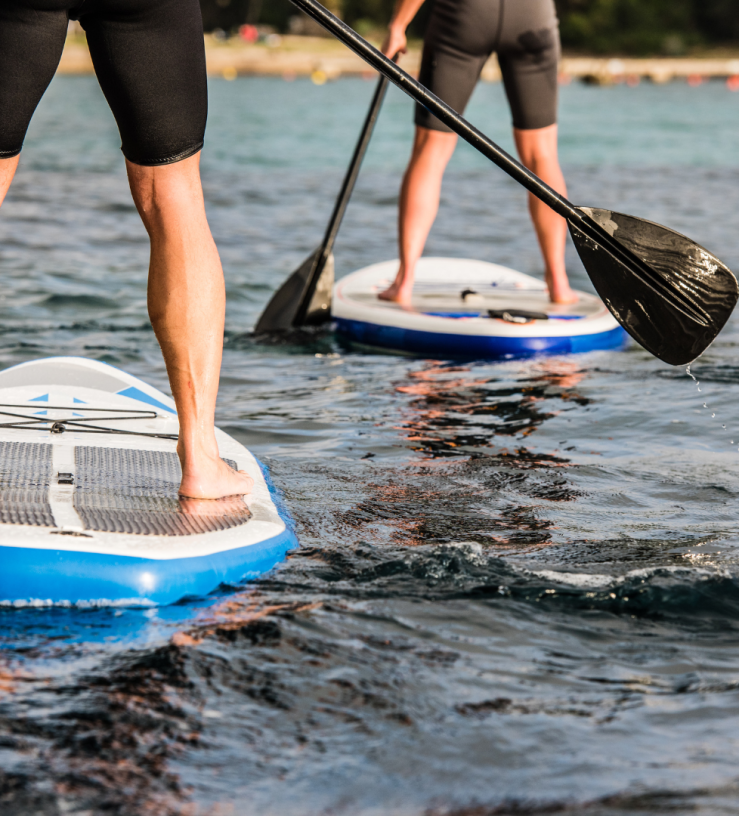 Photo of a two people paddleboarding to show workplace wellbeing