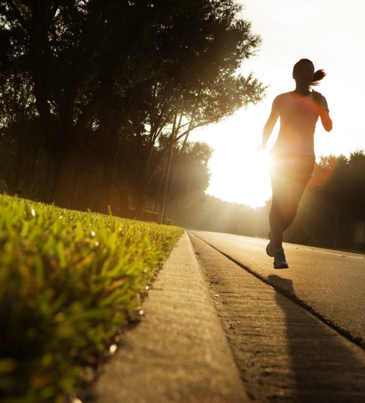 A photo of a woman running in the early morning