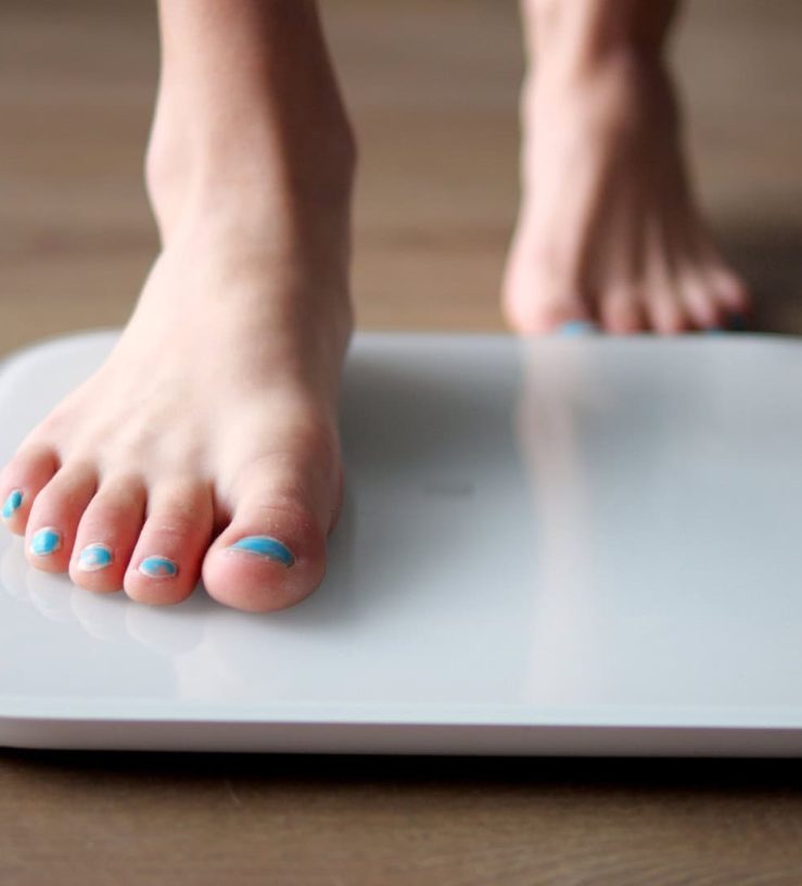 A photo of someone stepping onto weighing scales