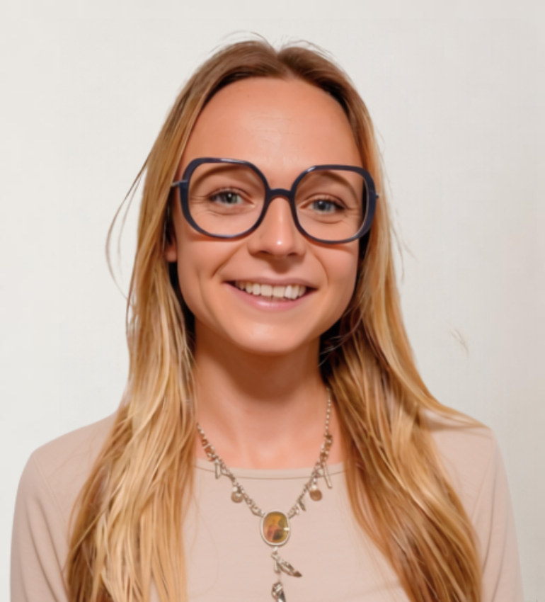 Gabrielle has long blonde hair and glasses, and is smiling